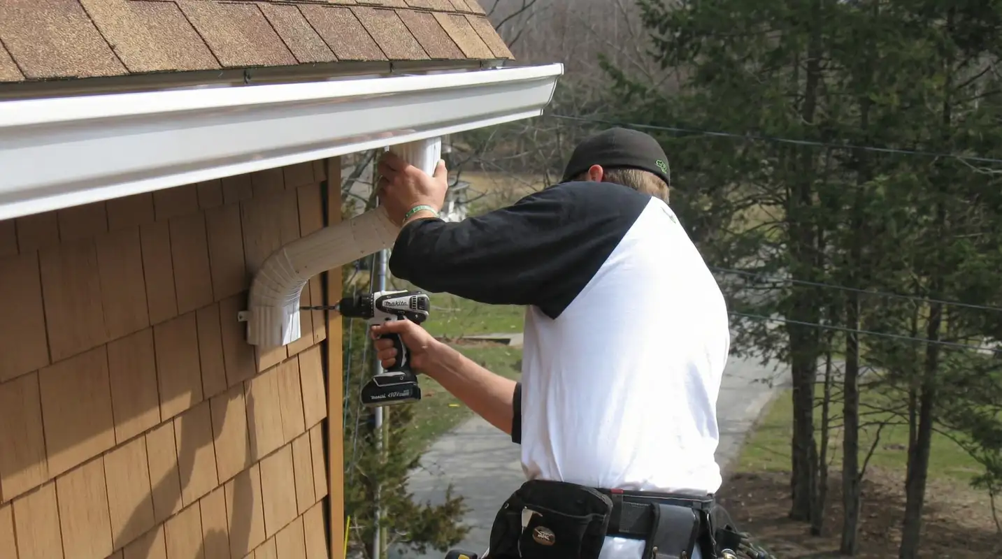 Professional contractor installing tan vinyl siding panels on a residential home exterior in Bakersfield, CA